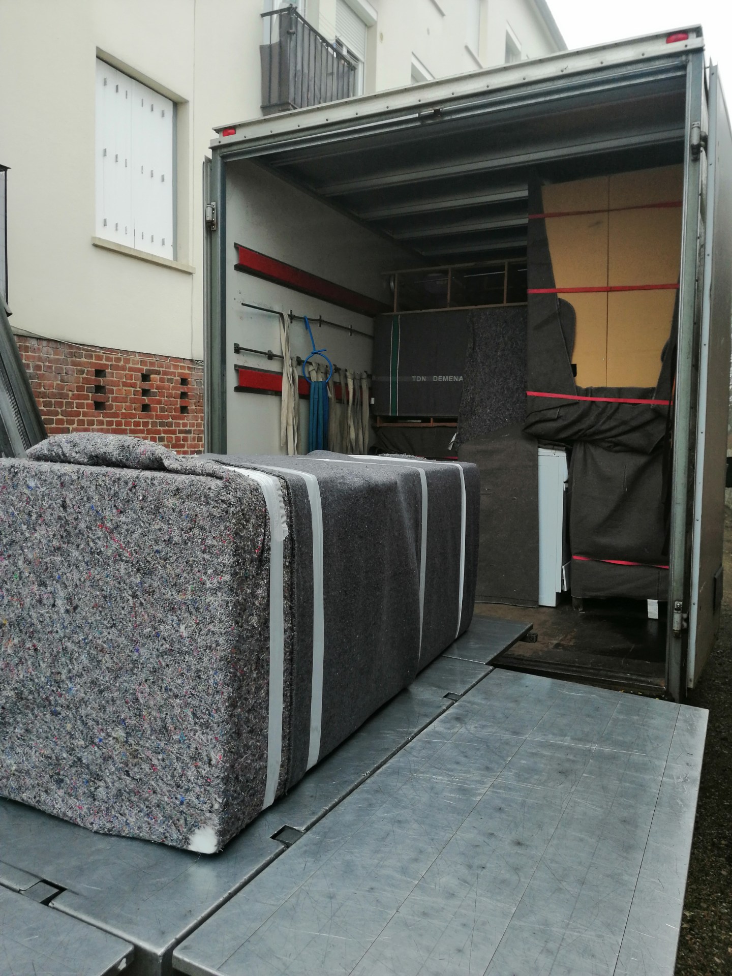 Grosses meubles rembourrés et équipements emballés dans un véhicule de déménagement prêt à partir, prêt à être transporté.