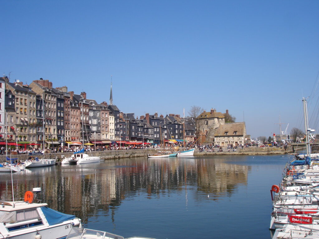 Vue sur le port de Dieppe en Normandie, rangées de maisons colorées, bateaux amarrés et promenade piétonne au bord de l’eau, idéal pour vivre en normandie.